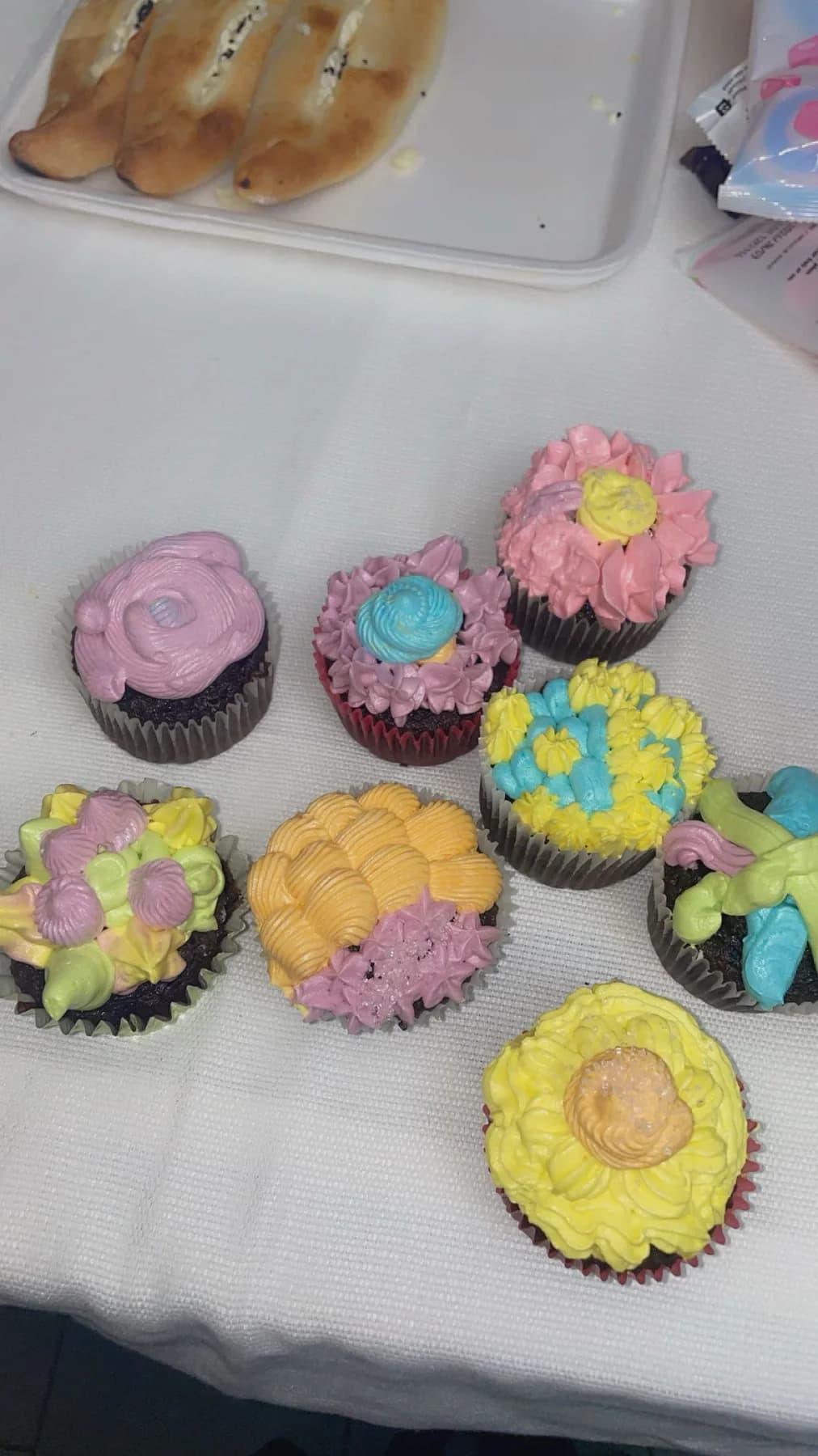 Colorful floral cupcakes arranged after hand piping