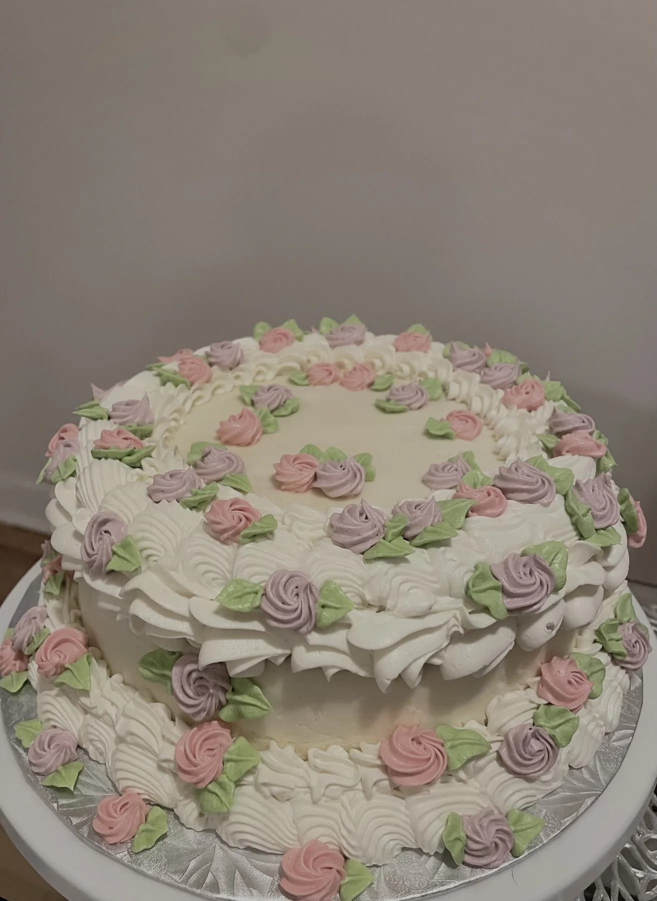 Close view of a white vintage cake with detailed floral buttercream piping