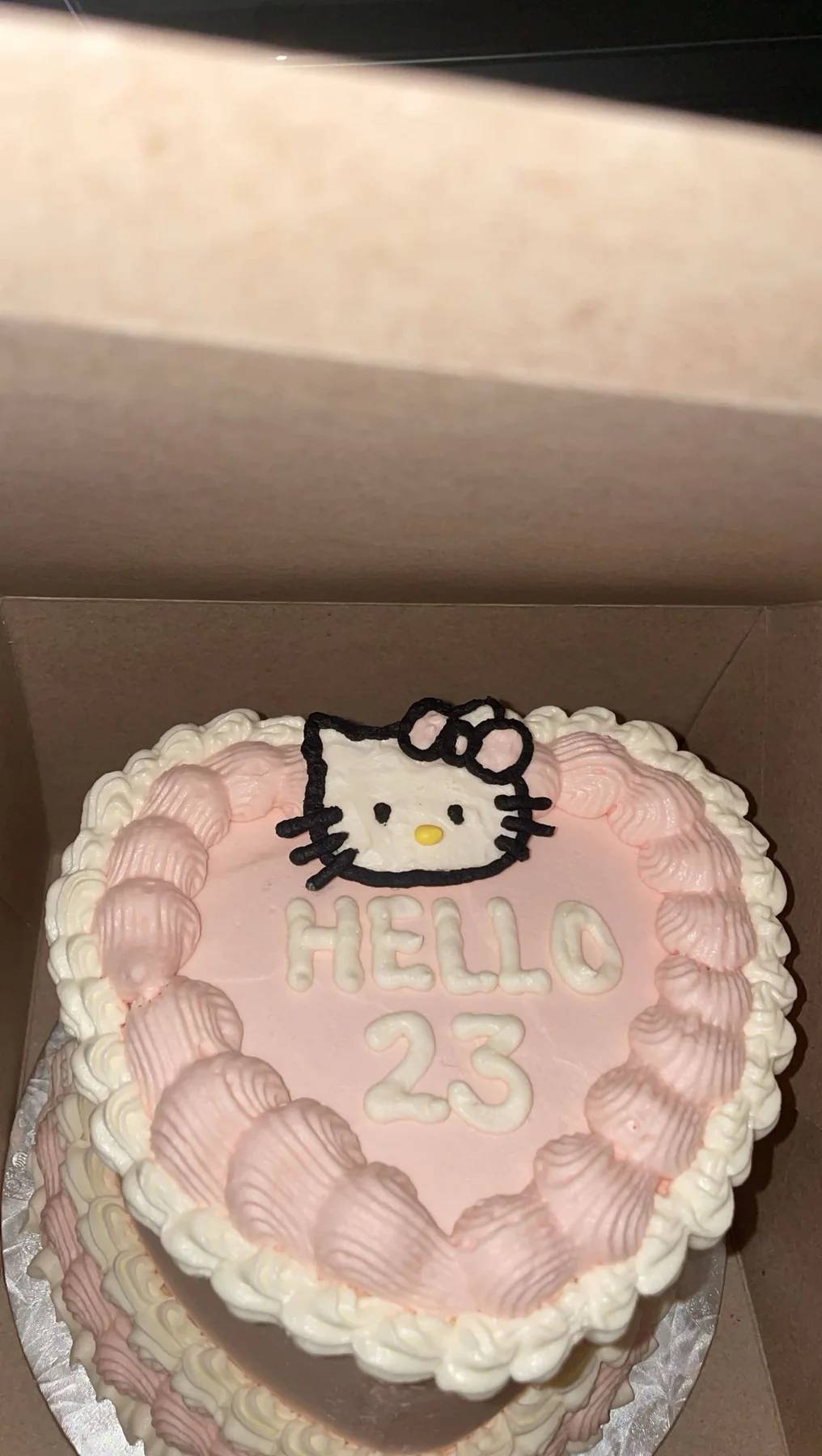 Pink heart-shaped cake with vintage piping and a Hello Kitty design