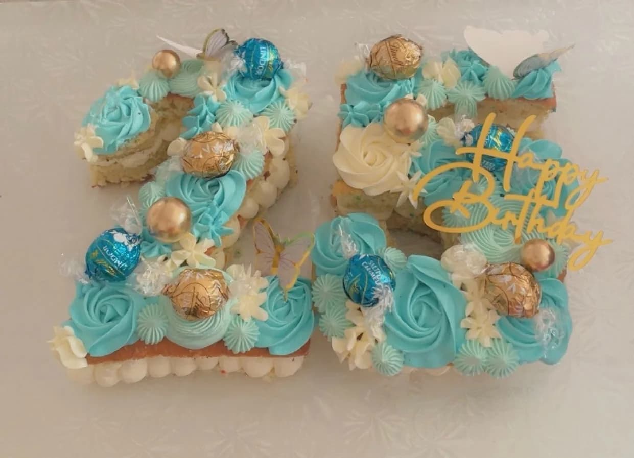 Turquoise number-shaped cupcake cake with gold and white decorations